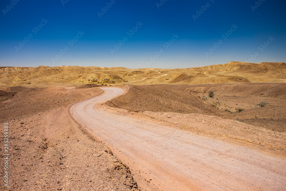 desert dry wasteland valley horizon scenic landscape view with lonely curved ground trail in Middle East hot environment 