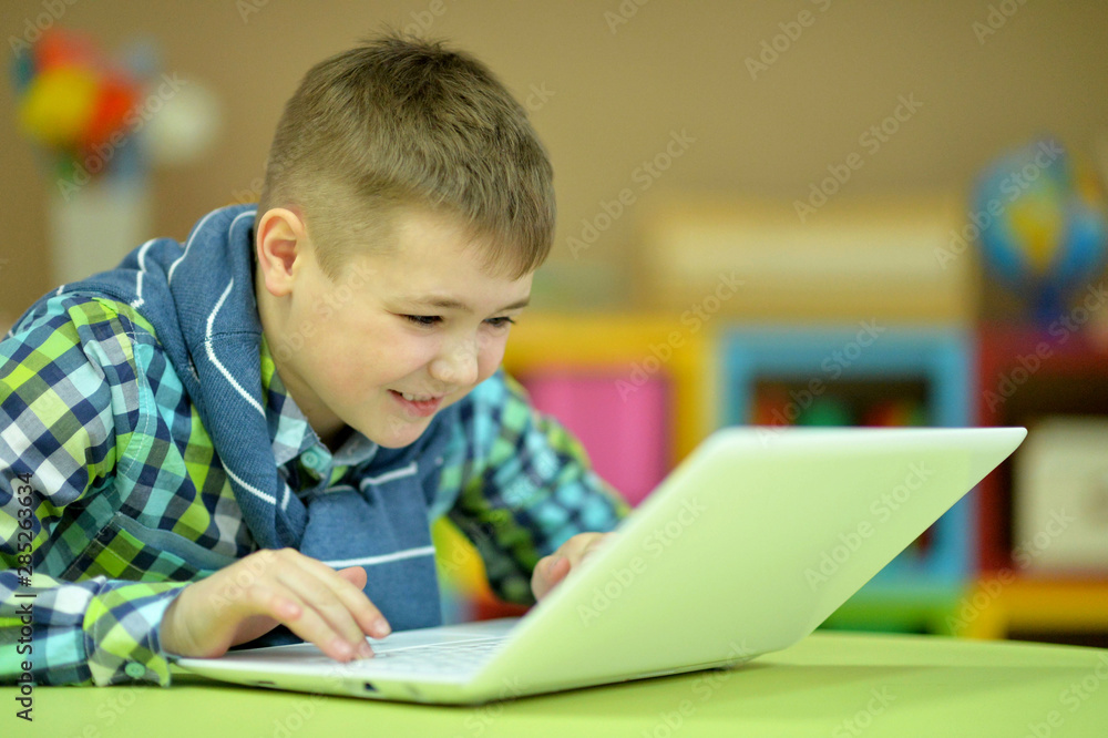 Portrait of cute boy using laptop in room Portrait of cute boy using laptop in room