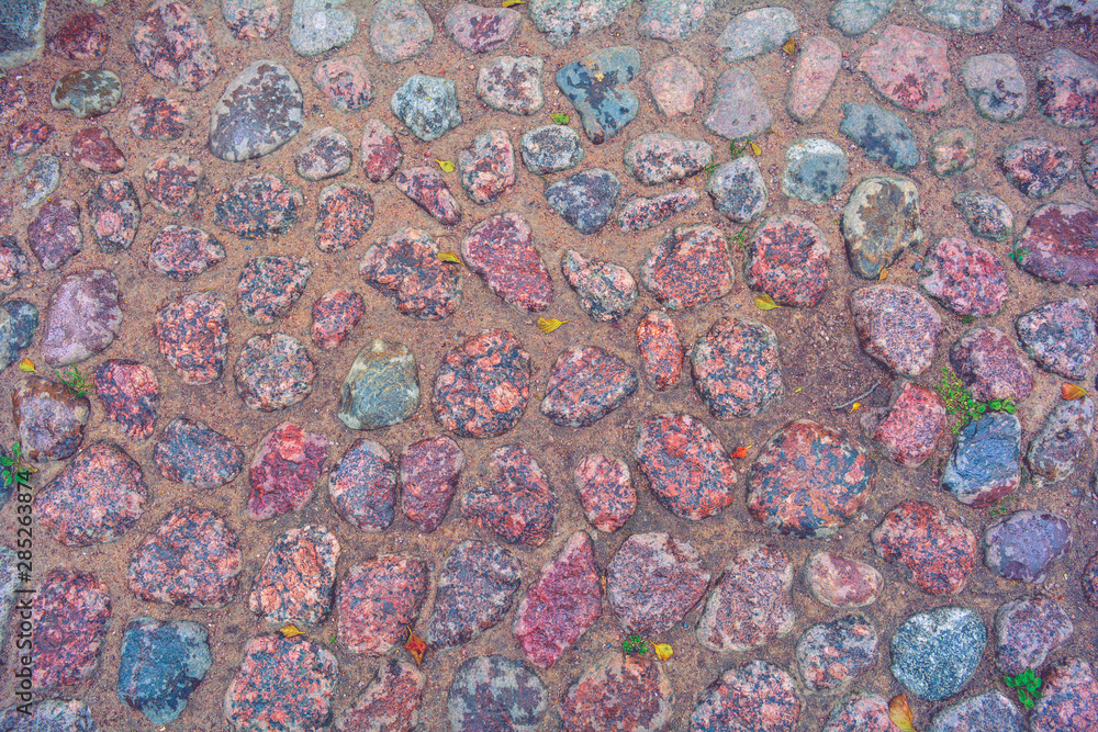 Stone pavement with rough wet granite boulders. Historic medieval cobble paving Stone pavement with rough wet granite boulders. Historic medieval cobble paving