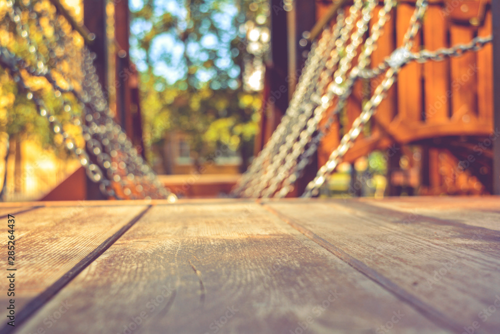 Swinging platform, hangs on chains in children's playground on sunny summer day Swinging platform, hangs on chains in children's playground on sunny summer day