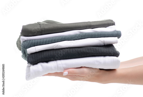 Stack folded green white clothing in hand on white background isolation