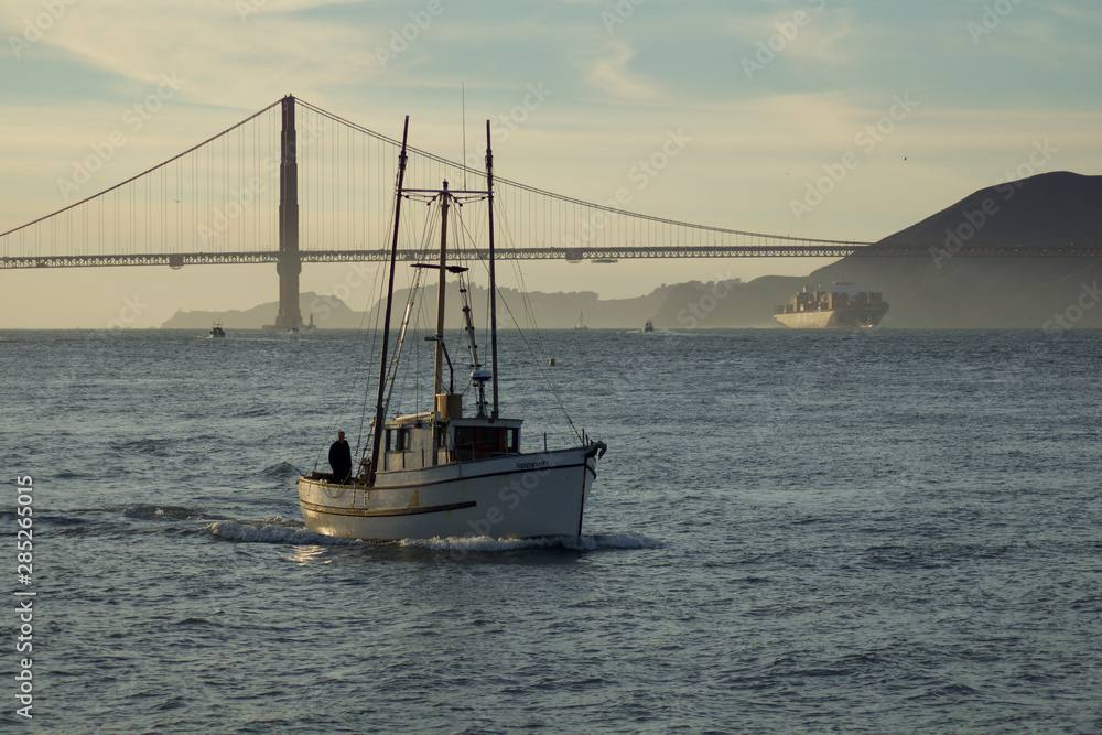 SAN FRANCISCO, CALIFORNIA, UNITED STATES - NOV 25th, 2018: Boat in San Francisco Bay with Golden Gate Bridge in the background during sunset