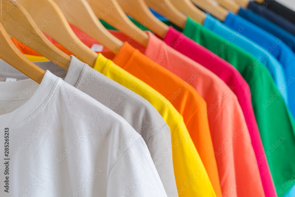 Close up of Colorful t-shirts on hangers, apparel background Stock Photo |  Adobe Stock