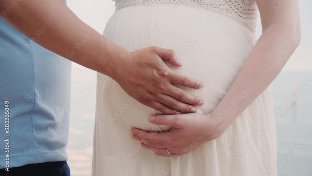 Hands of a young man hold hands of his pregnant wife Hands of a young man hold hands of his pregnant wife