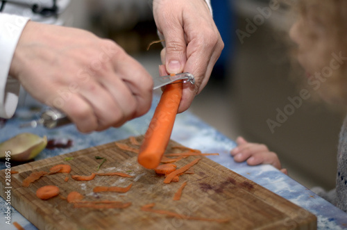 Hände beim Schälen einer Karotte