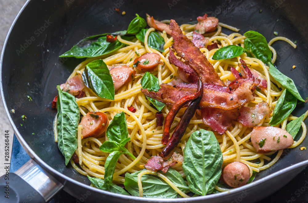 fusion food, spaghetti with fried crispy bacon ,sausage and basil leave, hot and spicy food, international cuisine fusion food, spaghetti with fried crispy bacon ,sausage and basil leave, hot and spicy food, international cuisine