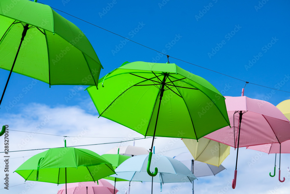 colorful umbrella line decorate outdoor moving by wind on blue sky white cloud