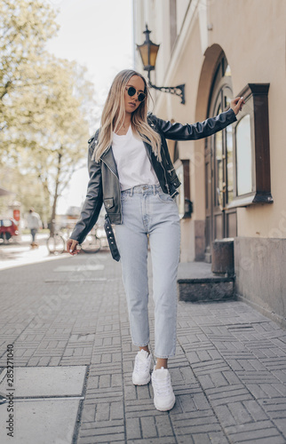 Stylish blogger posing in the street, wearing jacket. photo