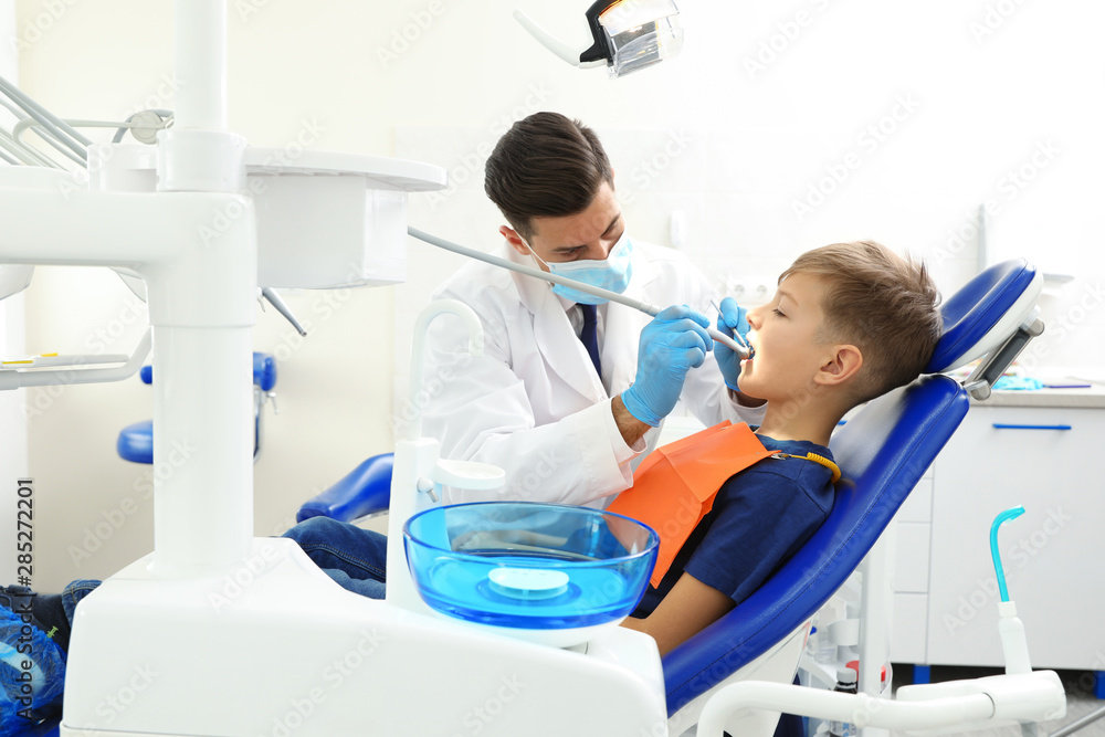 Professional dentist working with little boy in clinic Professional dentist working with little boy in clinic