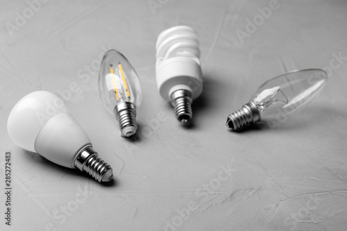 Different lamp bulbs on grey stone background