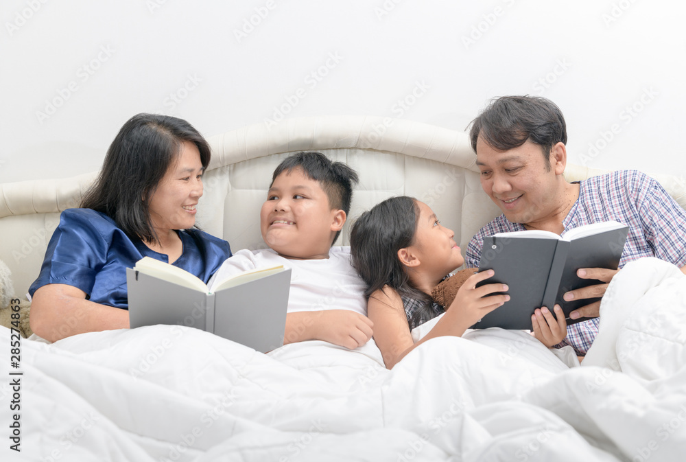 Happy Family reading a story on bed in the bedroom, Happy Family reading a story on bed in the bedroom,