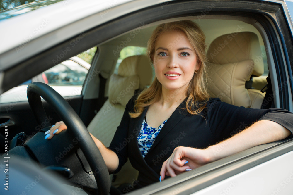 portrait of a beautiful young woman driving a car
