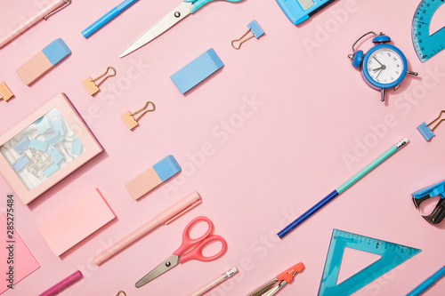 flat lay with blue school supplies and copy space isolated on pink