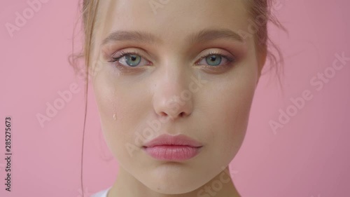 Crying girl on a pink background. Advertising, hair products, beauty salon, cosmetics, clothing. Fashion, boutique. Pink.