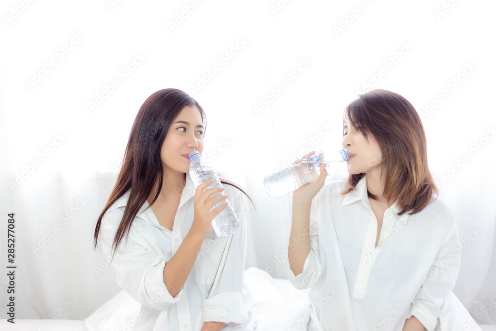 Charming beautiful women are drinking fresh water or mineral water every morning before get up from bed that make attractive beautiful girls get young, fresh and good health. They hold bottle of water Charming beautiful women are drinking fresh water or mineral water every morning before get up from bed that make attractive beautiful girls get young, fresh and good health. They hold bottle of water