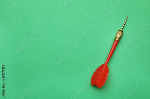 Red dart arrow on green background, top view with space for text