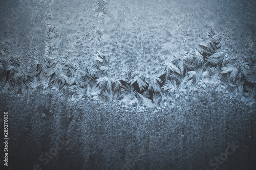 texture of frost and ice on glass as a pattern and ornament of a winter cold