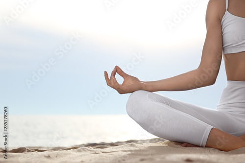Young woman practicing zen meditation on beach, closeup. Space for text