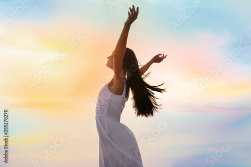 Young woman enjoying summer day against sky. Freedom of zen