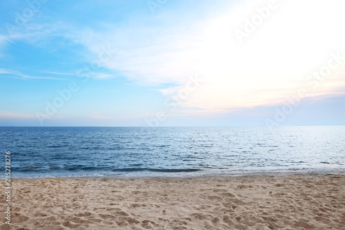 Picturesque landscape with calm sea and beach under blue sky