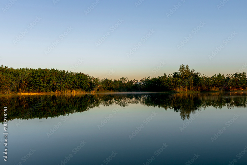 Morning summer landscape with tree on the banks of river and sky summer