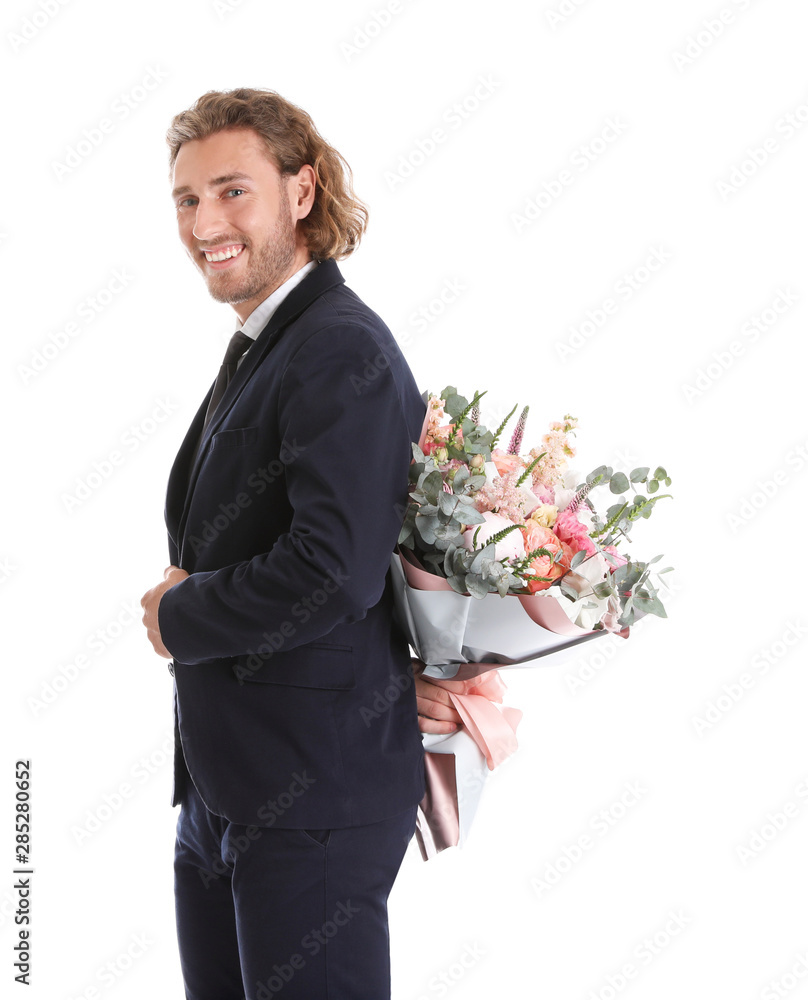 Young handsome man in stylish suit hiding beautiful flower bouquet behind his back on white background Young handsome man in stylish suit hiding beautiful flower bouquet behind his back on white background