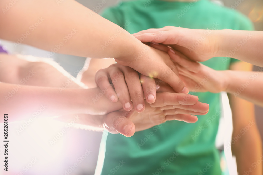Fototapeta premium Group of volunteers joining hands together, closeup
