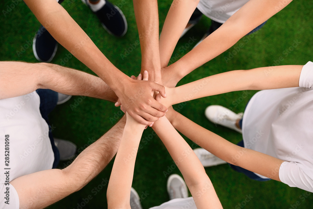 Group of volunteers joining hands together outdoors, top view Group of volunteers joining hands together outdoors, top view