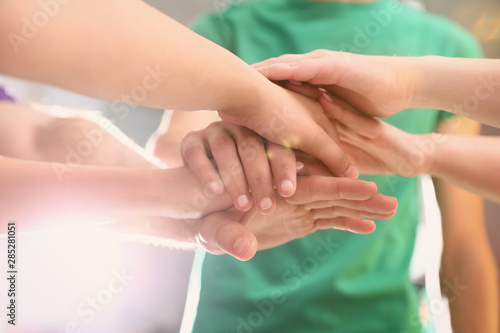 Group of volunteers joining hands together, closeup