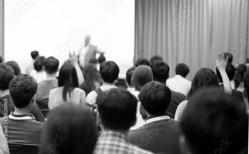 Seminar presenter at corporate conference giving speech. Speaker giving lecture to business audience. Executive manager leading discussion in hall during company training event. 