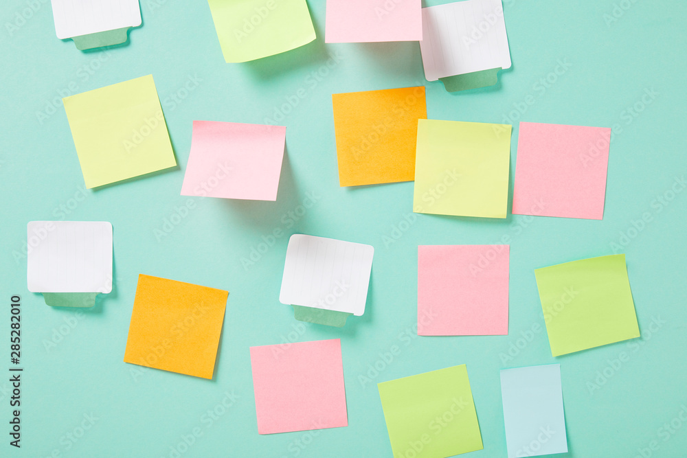 multicolored empty sticky notes with copy space on turquoise wall multicolored empty sticky notes with copy space on turquoise wall