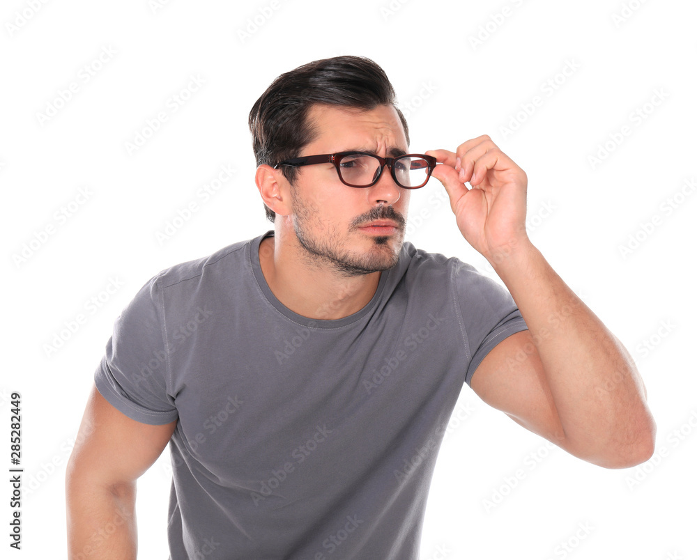Young man with vision problem wearing glasses on white background Young man with vision problem wearing glasses on white background