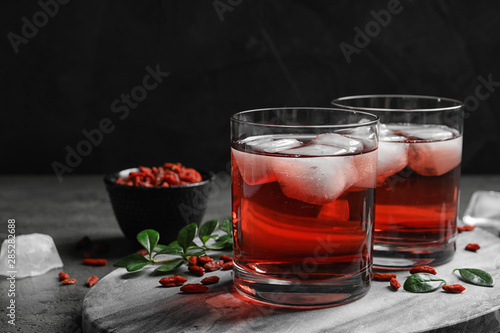 Healthy goji juice with ice in glasses on table