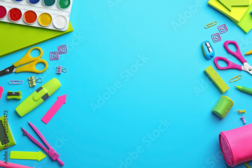 Frame made with colorful school stationery on light blue background, flat lay. Space for text
