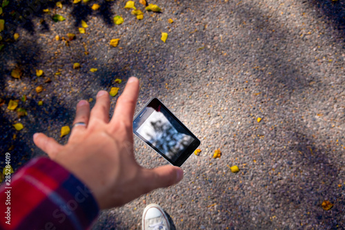Canvas-taulu Man dropping his smartphone ad trying to reach it