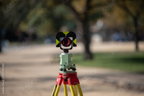 Modern Surveying total station, close up view on blurred park background.