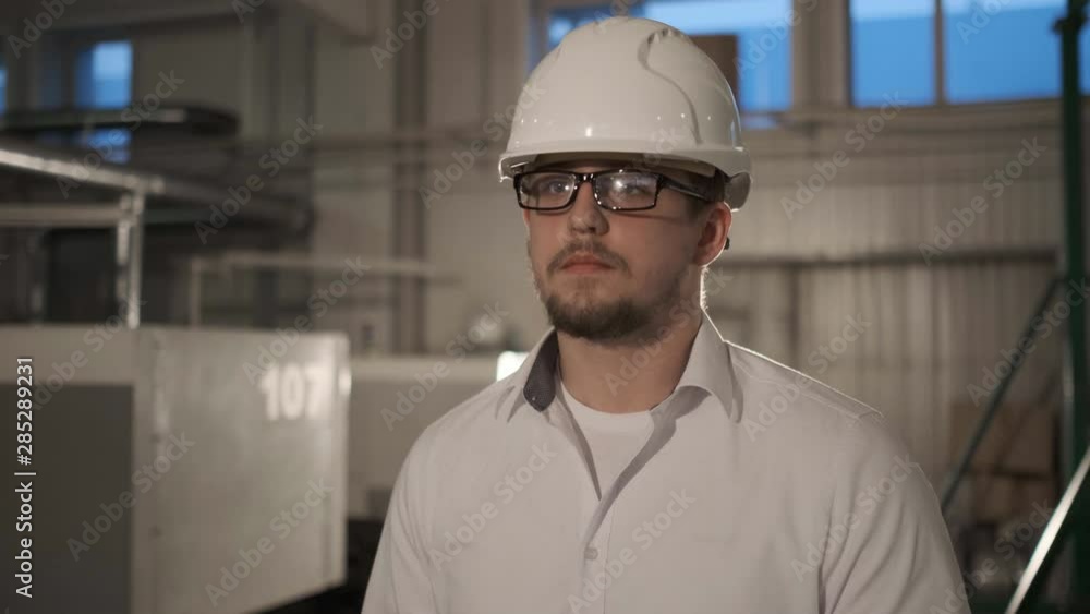 Engineer in hardhat is moving through a heavy industry factory with a tablet computer. Slow-Motion. 4k.