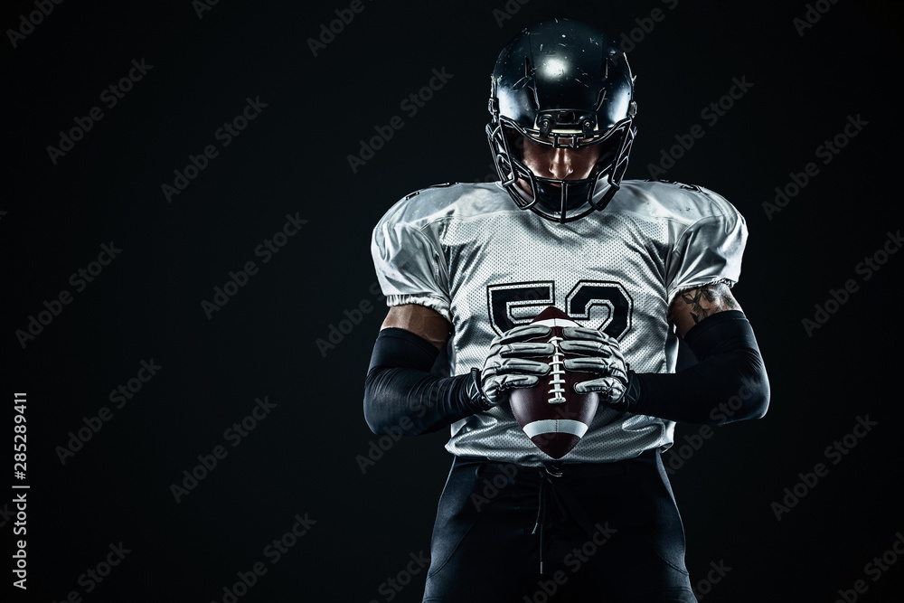 Fototapeta American football sportsman player in helmet on black background. Sport and motivation. Team sports.