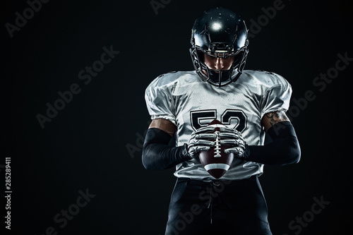 American football sportsman player in helmet on black background. Sport and motivation. Team sports.