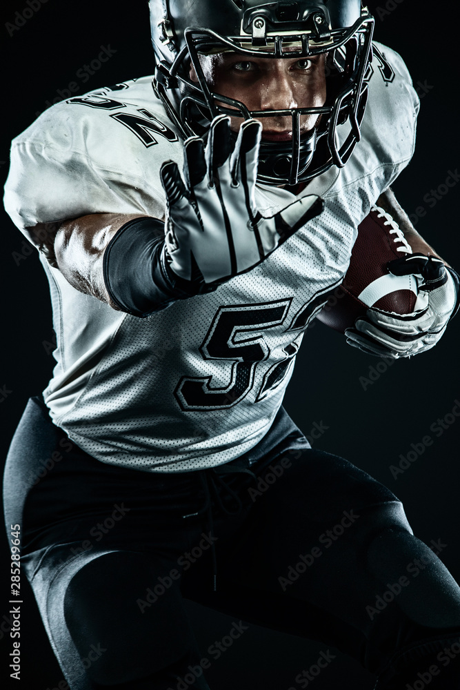 American football sportsman player in helmet isolated run in action on black background. Sport and motivation wallpaper. Team sports,