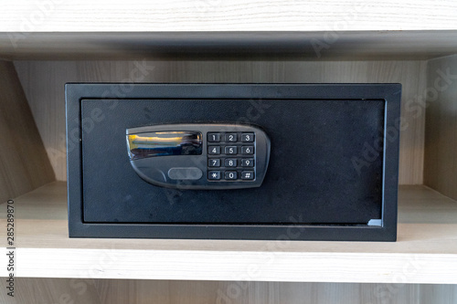 black safe box, stroungbox in the wood pattern shelf in resort bedroom.