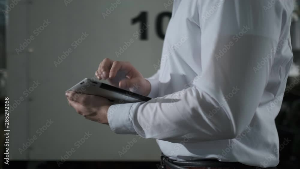 Engineer in hardhat is moving through a heavy industry factory with a tablet computer. Slow-Motion. 4k. Close-up Engineer in hardhat is moving through a heavy industry factory with a tablet computer. Slow-Motion. 4k. Close-up
