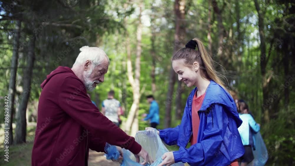 Group of fit people picking up litter in nature, a plogging concept. Group of fit people picking up litter in nature, a plogging concept.