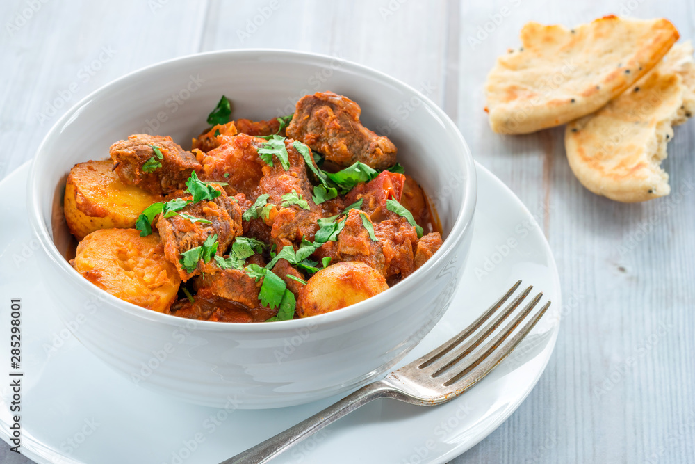 Aloo gosht with naan bread - lamb and potato curry - cuisine popular in Pakistan, Bangladesh and North India Aloo gosht with naan bread - lamb and potato curry - cuisine popular in Pakistan, Bangladesh and North India