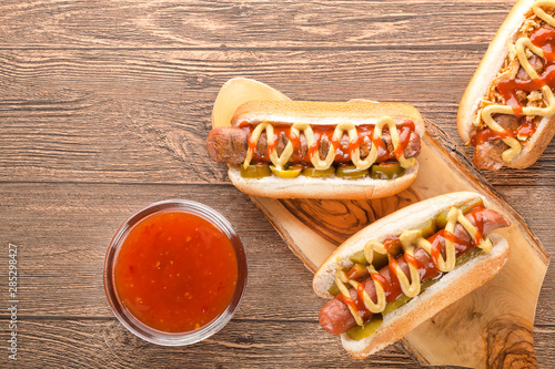 Hot dog with grilled sausage  mustard  and ketchup  onions  and greens on Paper background