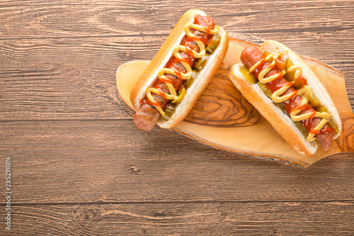 Hot dog with grilled sausage  mustard  and ketchup  onions  and greens on Paper background