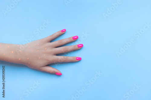 Stylish trendy female manicure. Beautiful neon plastic pink nails on blue background. Nail polish. Art manicure. Modern style.