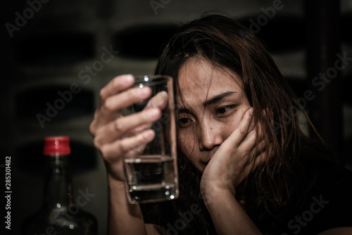 Asian woman drink vodka alone at home on night time,Thailand people,Stress woman drunk concept