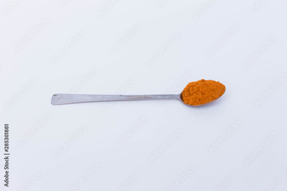 Curry powder in the spoon isolated on white background Curry powder in the spoon isolated on white background