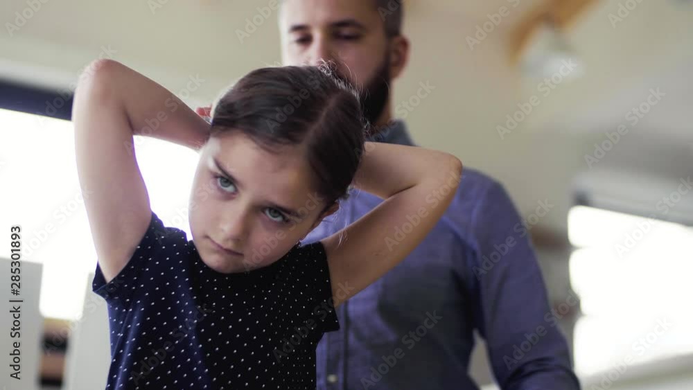 Mature father with small daughter indoors at home, combing hair. Mature father with small daughter indoors at home, combing hair.
